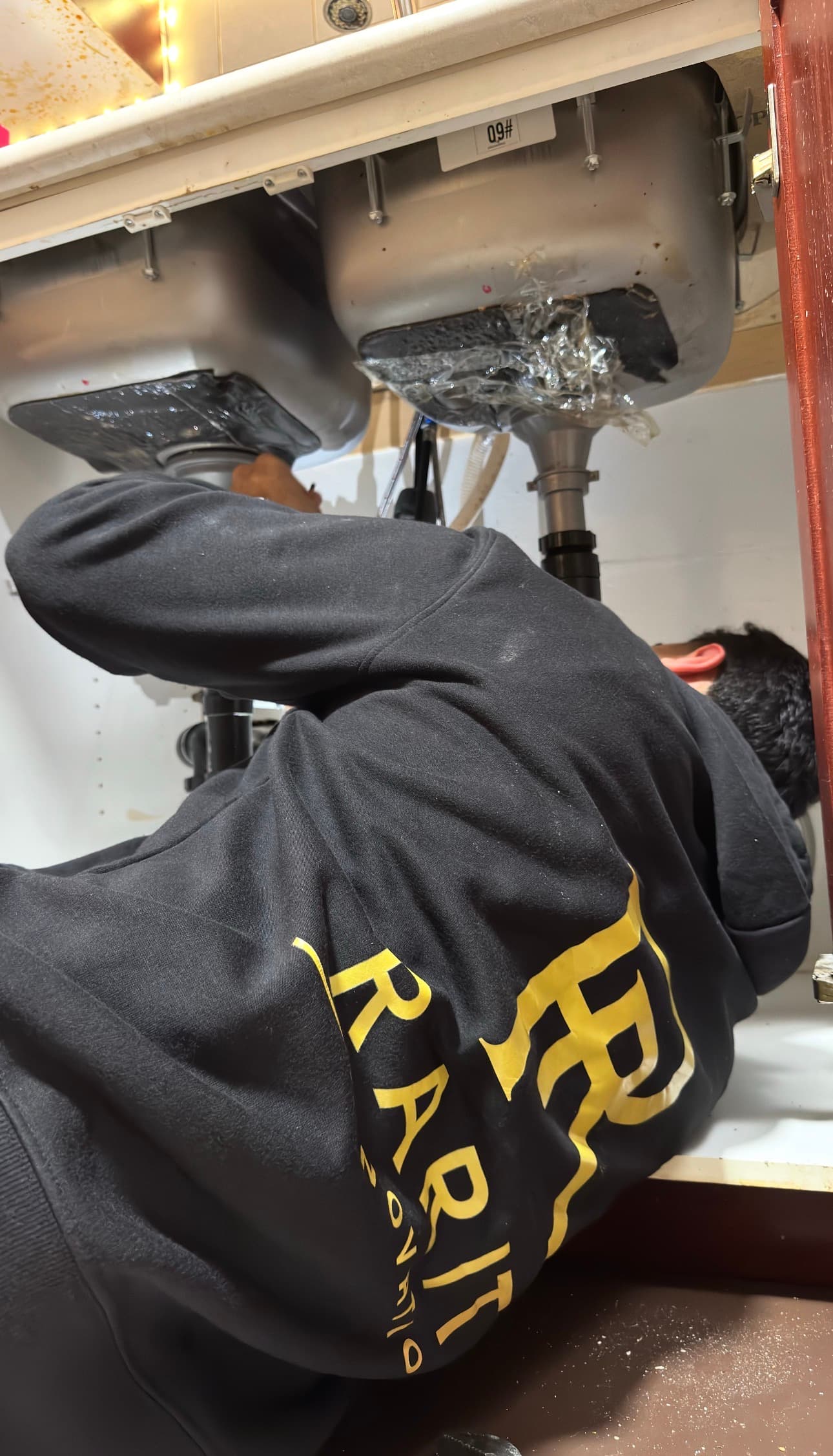Rarity Renovations team responding to water damage beneath a leaking sink