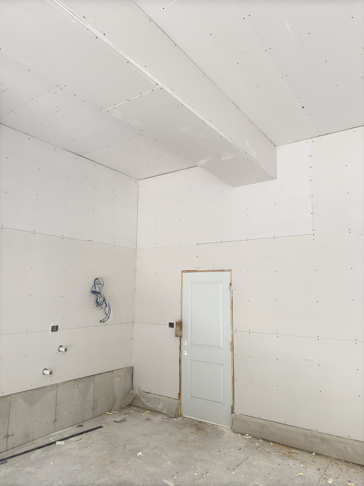 Drywall installed across high walls and a bulkhead during a GTA renovation